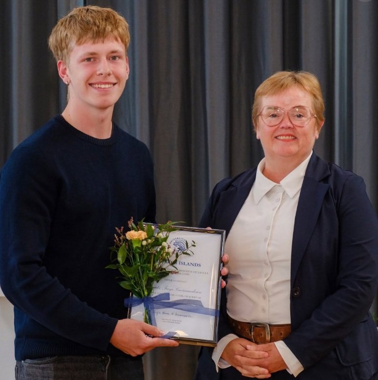 Bjarki tekur við verðlaununum ren þau veitti Silja Bára Ómarsdóttir, rektor H.Í.