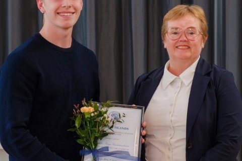 Bjarki tekur við verðlaununum, en þau veitti Silja Bára Ómarsdóttir, rektor H.Í.